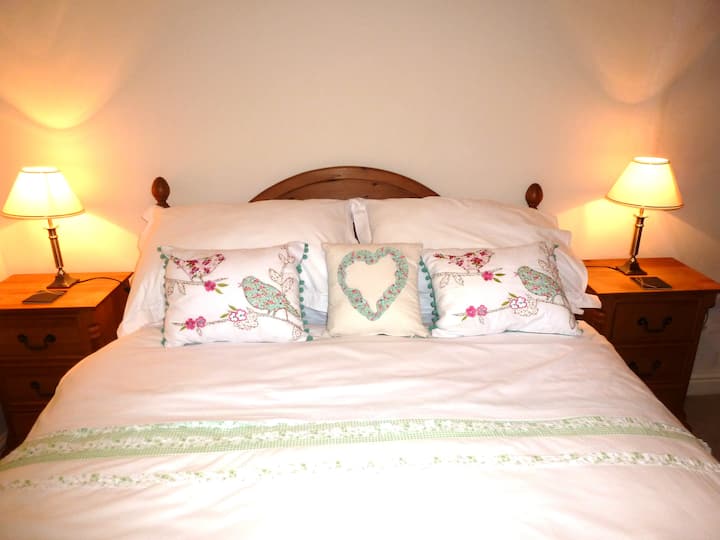 El dormitorio 2 tiene una cama doble con 2 lámparas de noche, un armario y una cómoda. Abre la ventana y escucha el agua corriente cayendo por la ladera. 