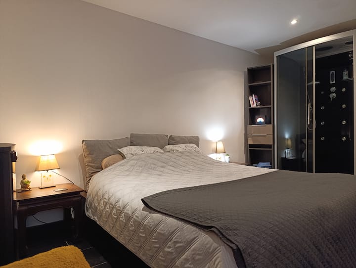 Cama extremadamente espaciosa con dos magníficas mesitas de noche de madera exótica.