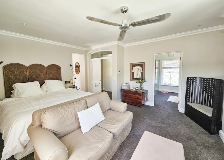 Главна спална соба на горниот кат - со брачен кревет, дизајнерски светилки Artemede Tizio, паметен телевизор, тавански вентилатор и целосна сопствена бања. 