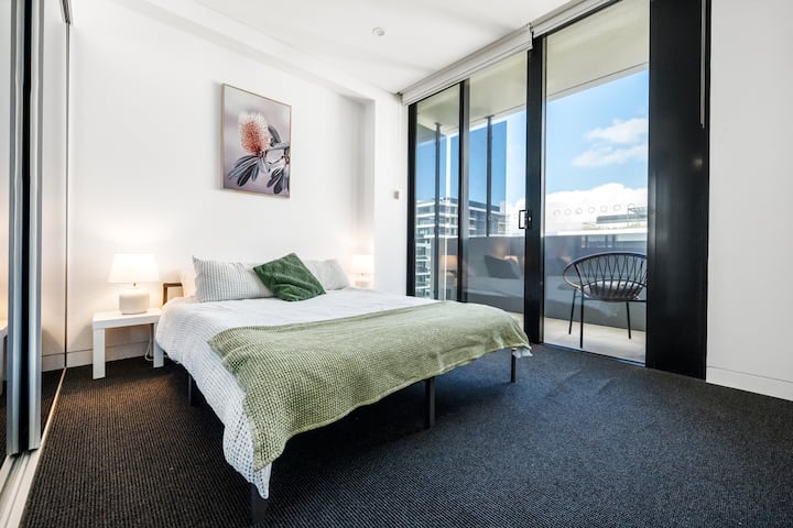 Accogliente camera da letto matrimoniale con lenzuola fresche e un'atmosfera tranquilla. Un piccolo balcone privato con vista sul complesso. 