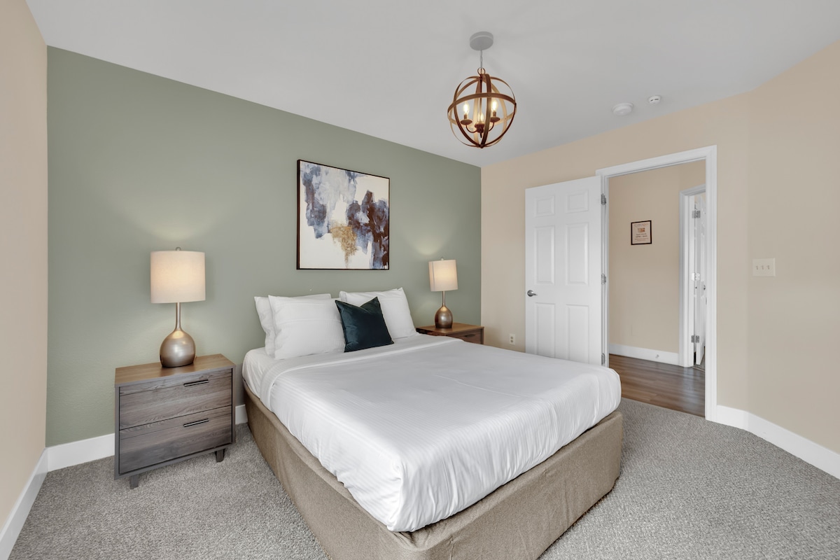 Upokojujúci priestor s plyšovou posteľnou bielizňou a relaxačnou atmosférou, ideálny na oddych po dlhom dni.