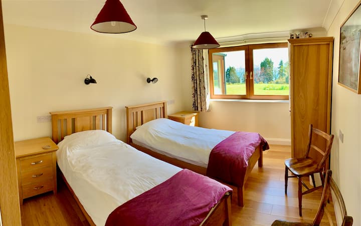 Camas individuales y colchones con tensión firme adecuados para aquellos que pesan más de 8 piedras. Mesitas de noche, sillas y armario con baños adyacentes y baño con ducha.