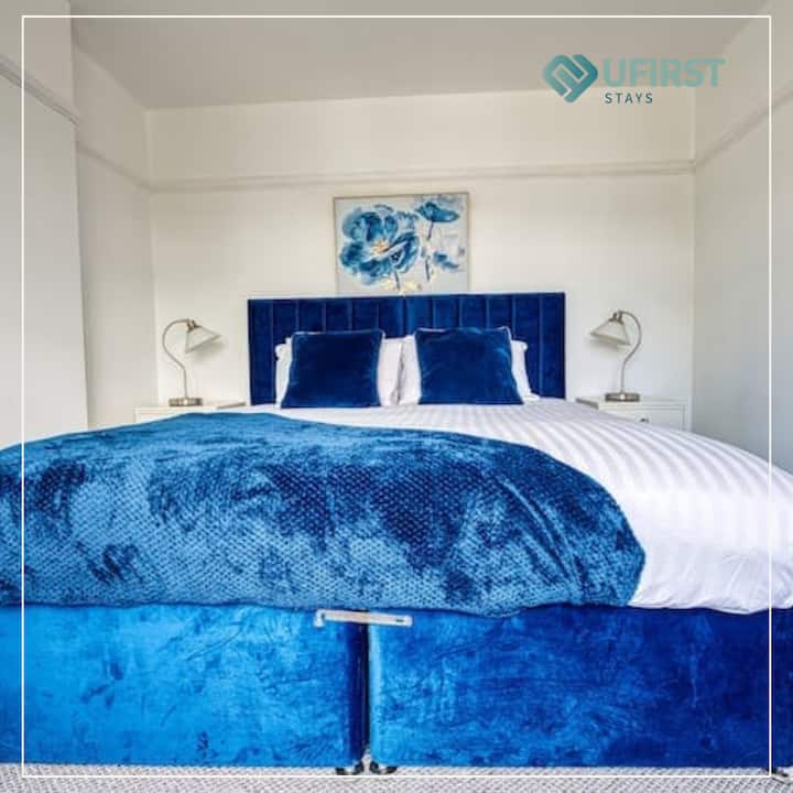 Oddýchnite si vo veľkom štýle v tejto priestrannej spálni s luxusnou manželskou posteľou, elegantnými nočnými stolíkmi, teplým osvetlením, elegantným umeleckým dielom na stene a oknom, ktoré vpúšťa ranné slnko.

