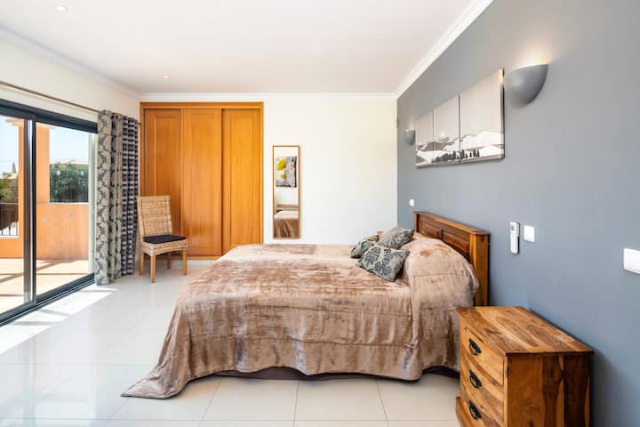 Двойна стая на първия етаж с изглед към градината и басейна. Голяма тераса и достъп до зоната за отдих.