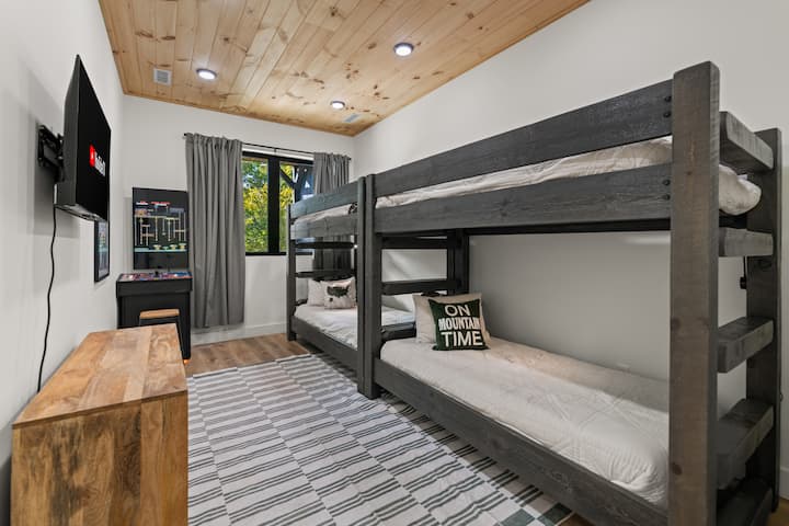 La habitación de literas está en el nivel inferior y cuenta con cómodos colchones, un juego de arcade y televisión inteligente. El baño completo está junto al dormitorio 