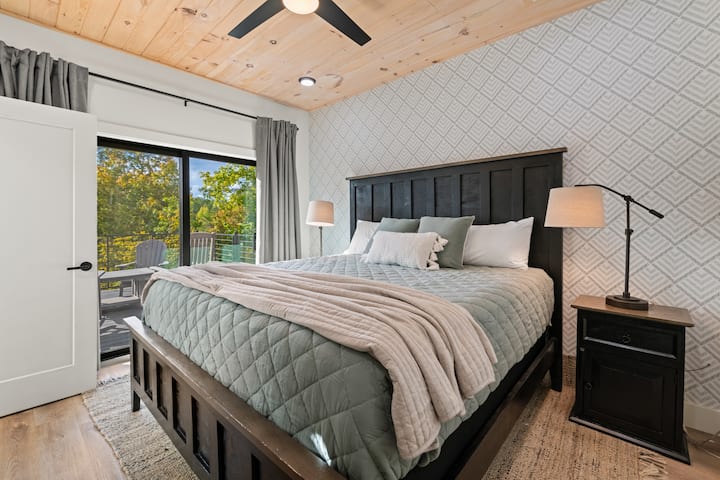 Esta suite principal del nivel principal cuenta con cama tamaño king, televisión inteligente, moderno baño completo adjunto y acceso al balcón. 