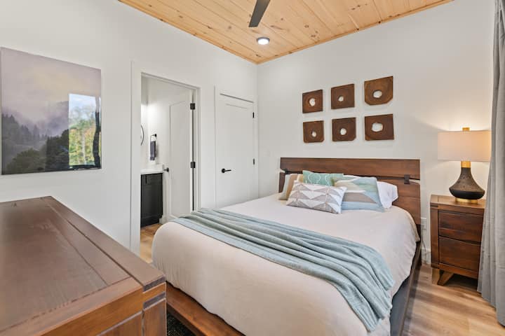 Este dormitorio del nivel superior tiene un baño completo adjunto y cuenta con una cama tamaño queen y televisión inteligente. 