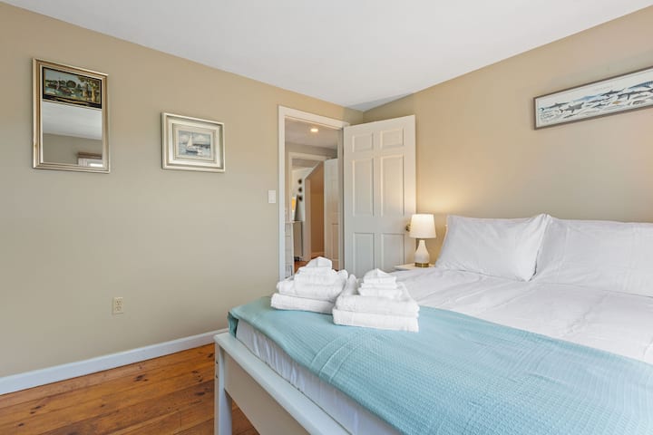 Second floor bedroom with full size bed, closet, chair, and hotel quality linens. 