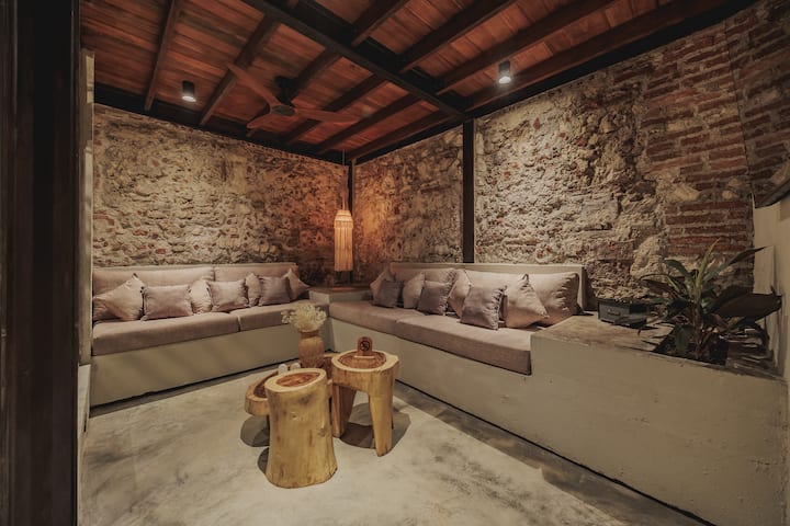 La sala de estar de Villa La Santísima combina el encanto colonial con la elegancia moderna. Con muebles de lujo, amplia luz natural y decoración artística, ofrece un ambiente sereno y acogedor.