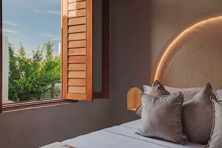 Las habitaciones de Villa La Santísima, con una cama tamaño queen y aire acondicionado, combinan un elegante estilo colonial con el lujo moderno, creando un ambiente sereno y refinado para la relajación.