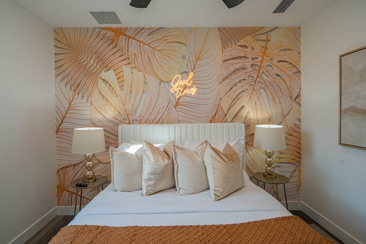 Golden Oasis – Een dromerige slaapkamer met een gedurfde muurschildering met gouden palmblad, zachte kussens en warme verlichting voor het perfecte toevluchtsoord. ✨