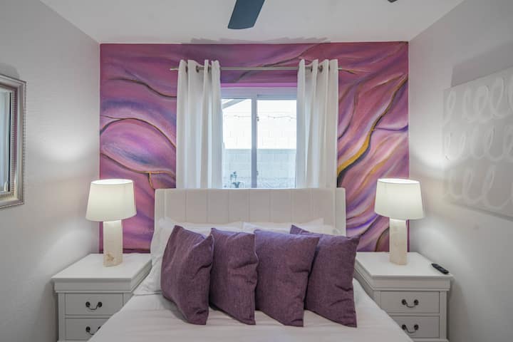 Lavender Dreams  – Een gezellige slaapkamer met rijke paarse tinten, een zacht bed en artistieke muuraccenten voor een serene ontsnapping.