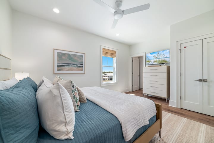 Chambre king size avec télévision connectée, commode et salle de bain privée attenante. 