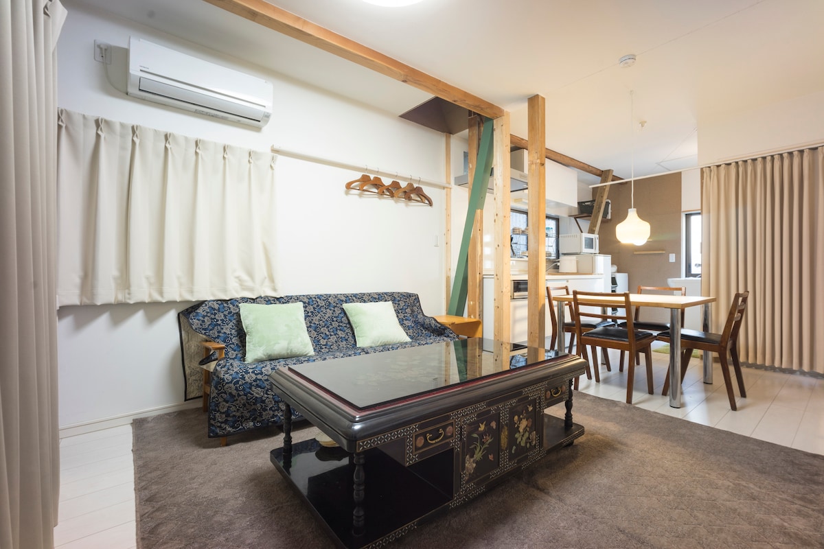 コンパクトな空間ながら、大き目の中国アンティークテーブルを中心とする落ち着きのあるリビングスペースになっています。二人掛けのソファと、階段側にベンチシートもあり、くつろいだり、おしゃべりしたり、調べ物をしたりするのに、最適のスペースになっています。奥に見えるのがDK、その奥が洗面になっています。