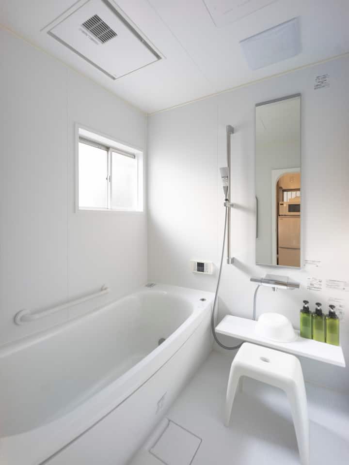 窓から入る光で明るく広い（1.65m角）浴室は、暖房乾燥機も備えていますので、冬も暖かく入浴を楽しむことがができます。
また脱衣コーナー（ダイニングとカーテンで仕切れる）には、大きな洗面台と洗濯機が用意されて、洗濯洗剤や物干しハンガーも用意されています。またコーナーのすぐ横には勝手口がありますので、その外に少量の洗濯物を干すこともできます。徒歩圏にランドリーもあるので、大量の洗濯はそちらがお勧めです。