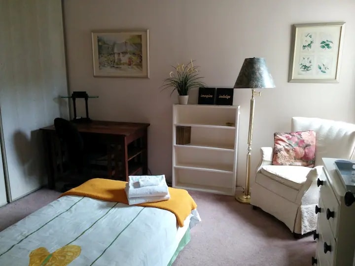 غرفة نوم مريحة ومفروشة بسرير واحد ومكتب خشبي قوي وكرسي جاهز مريح ومساحة خزانة واسعة.