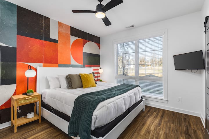 Unit #2: Bedroom #5 on the ground floor with a king bed, ceiling fan, Smart TV, and ensuite bathroom.