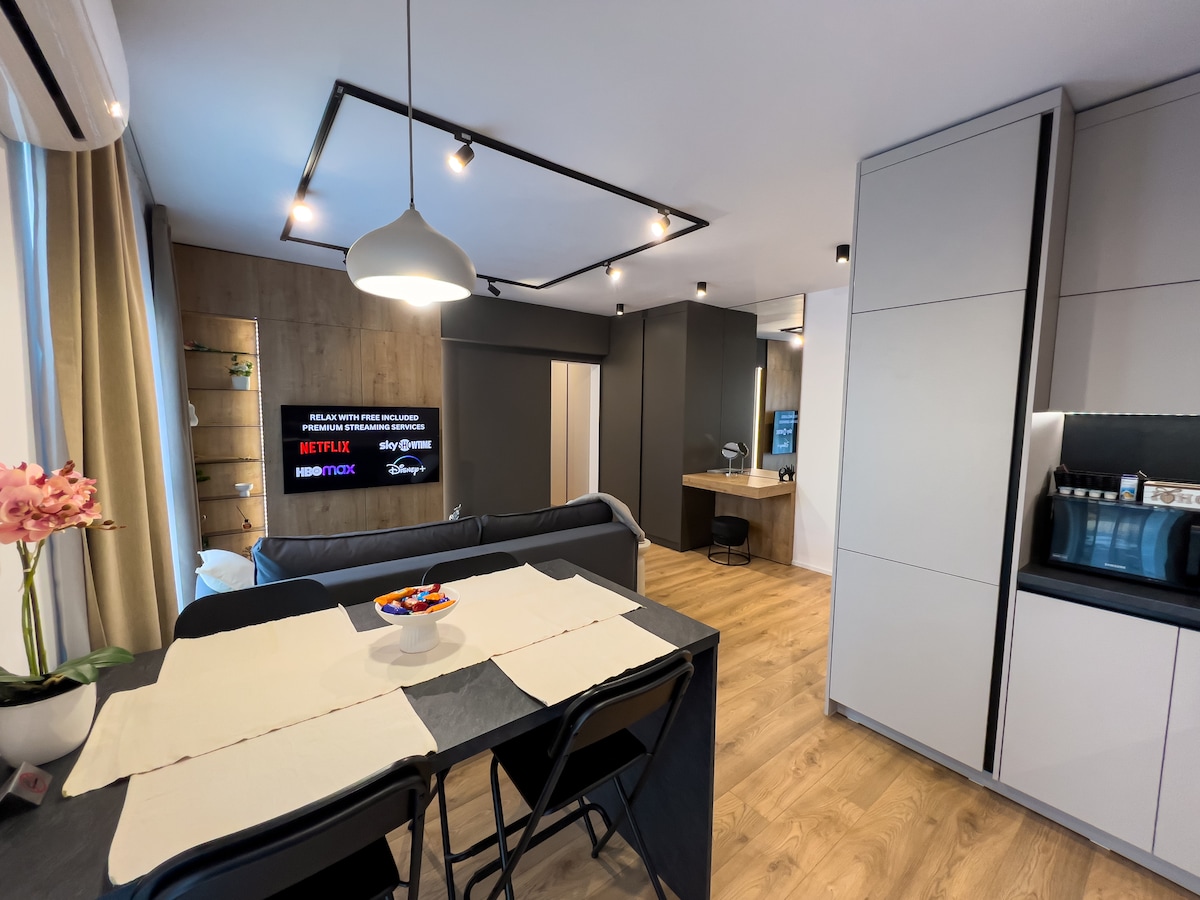 Moderna sala de estar inteligente con un sofá ampliable de 140 cm, servicios de streaming premium incluidos (Netflix, Disney+, Max, SkyShowtime) y juegos de mesa. Disfruta de un espacio acogedor y tecnológico perfecto para relajarse, entretenerse o socializar.