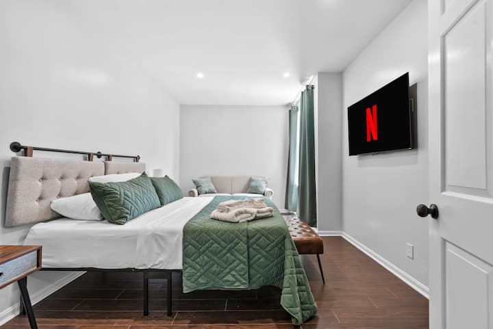 这间时尚的加大双人床房配有舒适的绿色装饰、豪华长凳和舒适的双人沙发，让您放松身心。 在55英寸智能电视上观看您最喜爱的节目。 柔和的灯光和现代风格使这里成为放松身心和恢复活力的完美空间。