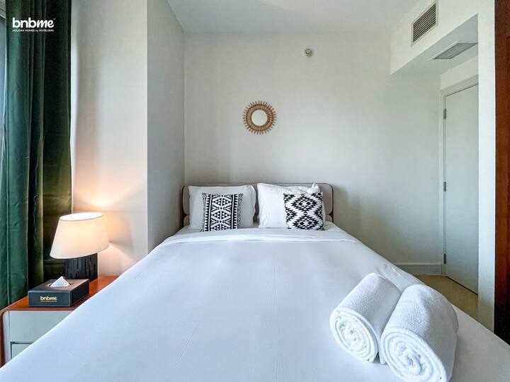 Un dormitorio moderno y acogedor con una cama tamaño king, a pocos pasos de un lujoso baño común.