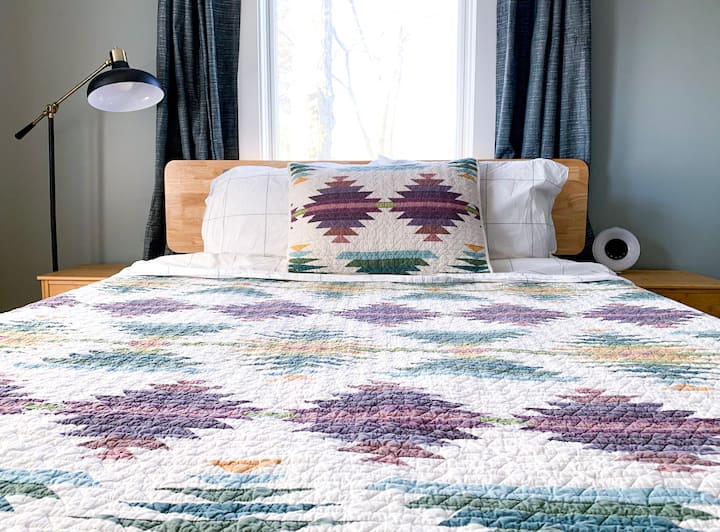 Chambre principale avec lit Queen Size, deux tables de chevet et oreillers et couvertures supplémentaires