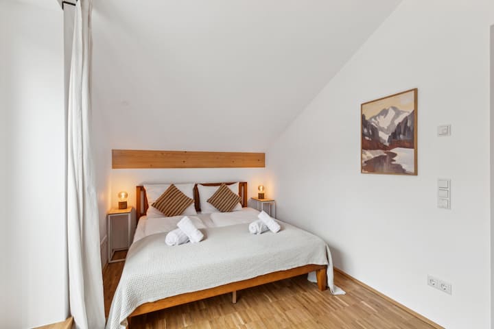 ห้องนอนเชิญคุณมาพักผ่อนและผ่อนคลายยามค่ำคืนและสร้างความประทับใจด้วยการตกแต่งภายในด้วยไม้แบบบาวาเรียแบบดั้งเดิมซึ่งสร้างบรรยากาศที่อบอุ่นและแท้จริง
