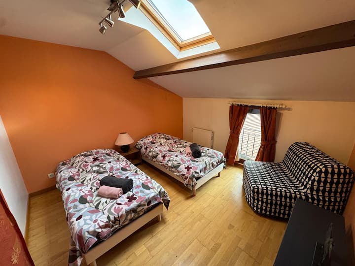 Une chambre lumineuse avec deux lits simples, parfaite pour un séjour confortable.