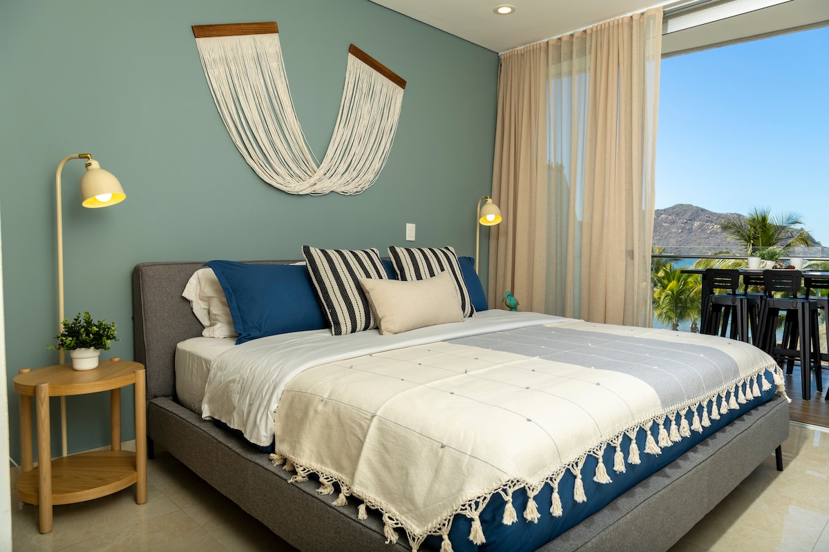 Chambre principale avec vue sur la mer et télévision intelligente.