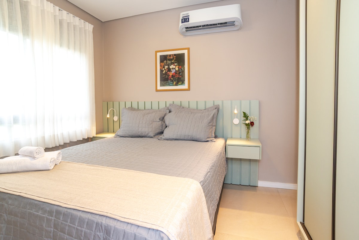 Utamu wa rangi laini, mguso wa kawaida wa mchoro wa maua na mwanga wa asili huunda mazingira ya kupumzika na utulivu — chumba kilichobuniwa kukaribisha kwa haiba na utulivu.