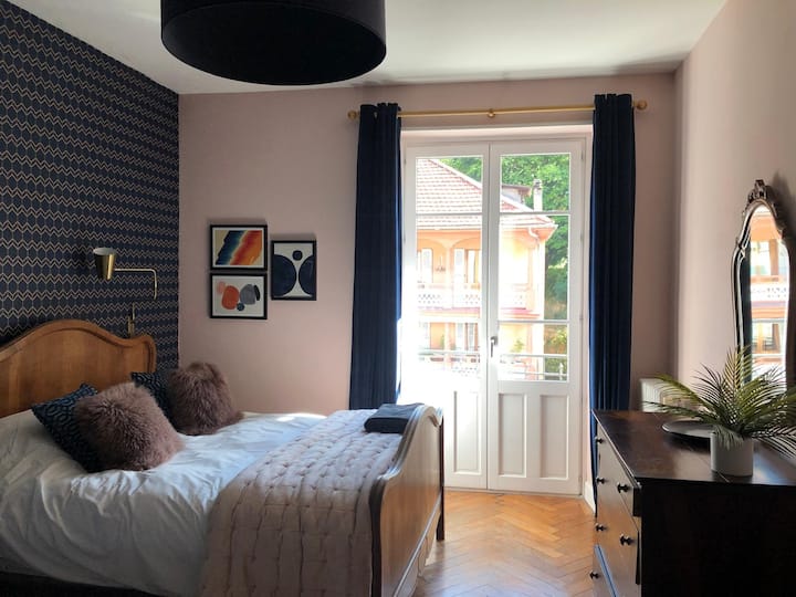 ห้องนอนหลักพร้อมระเบียง ตู้เสื้อผ้าขนาดใหญ่และเตียงควีนไซส์