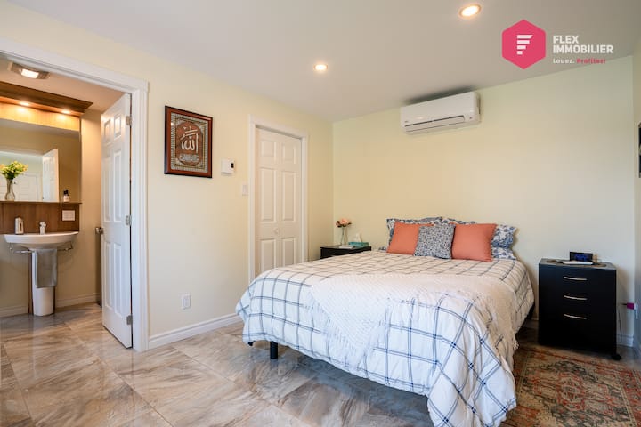 Chambre #1 au rez-de-chaussée avec très confortable lit queen, salle de bains attenante, climatisation et TVHD de 47 po