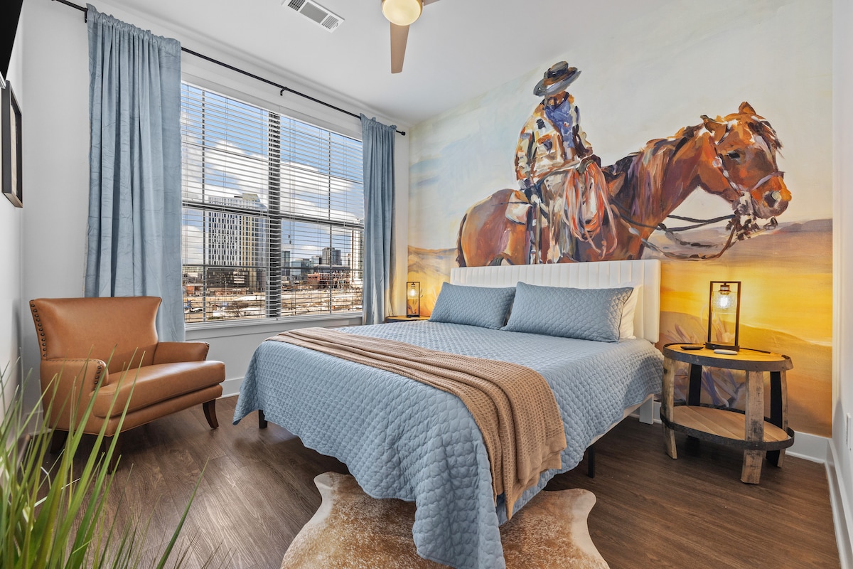 Საძინებელი | კოვბოის მოხატულობა + საწოლი დიდი ხნით | მთავარი სართული
Დაისვენეთ დასავლეთში შთაგონებულ ამ თამამ საძინებელში, საიდანაც იშლება შთამბეჭდავი მზის ჩასვლის კოვბოის მოხატულობა, რბილი ლურჯი თეთრეული და ჰორიზონტალური ხედები. Სოფლის ხიბლი აკმაყოფილებს ქალაქის სტილს ნეშვილში დასვენებისთვის.