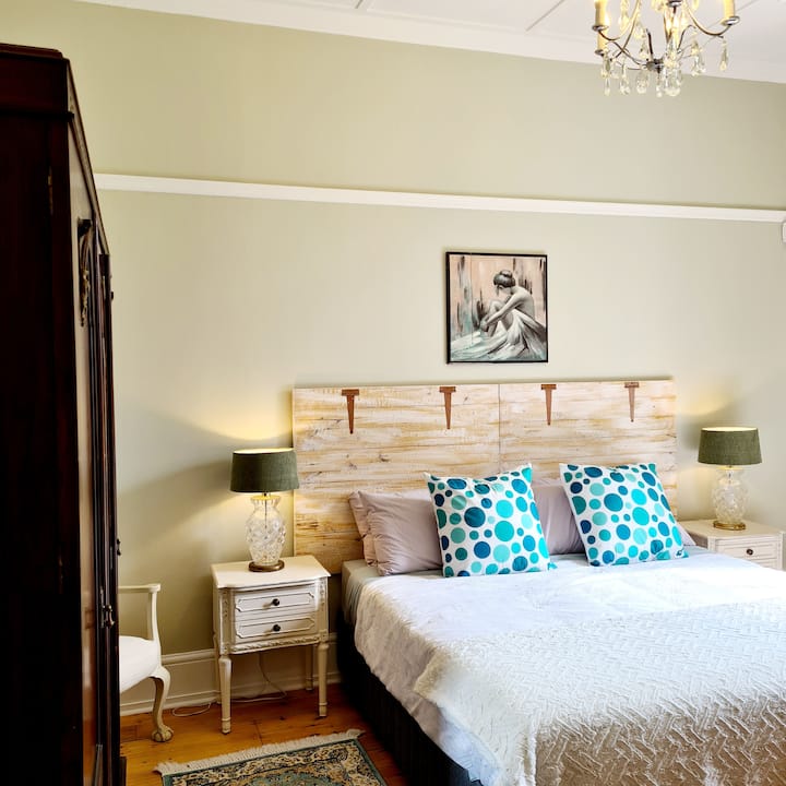 Rondebosch-soveværelset - det største af de fire i huset. Den har en ekstra lang kingsize-seng med udsigt over forhaven. Vintagetæpper på begge sider af sengen, så man træder ned på noget blødt og varmt.