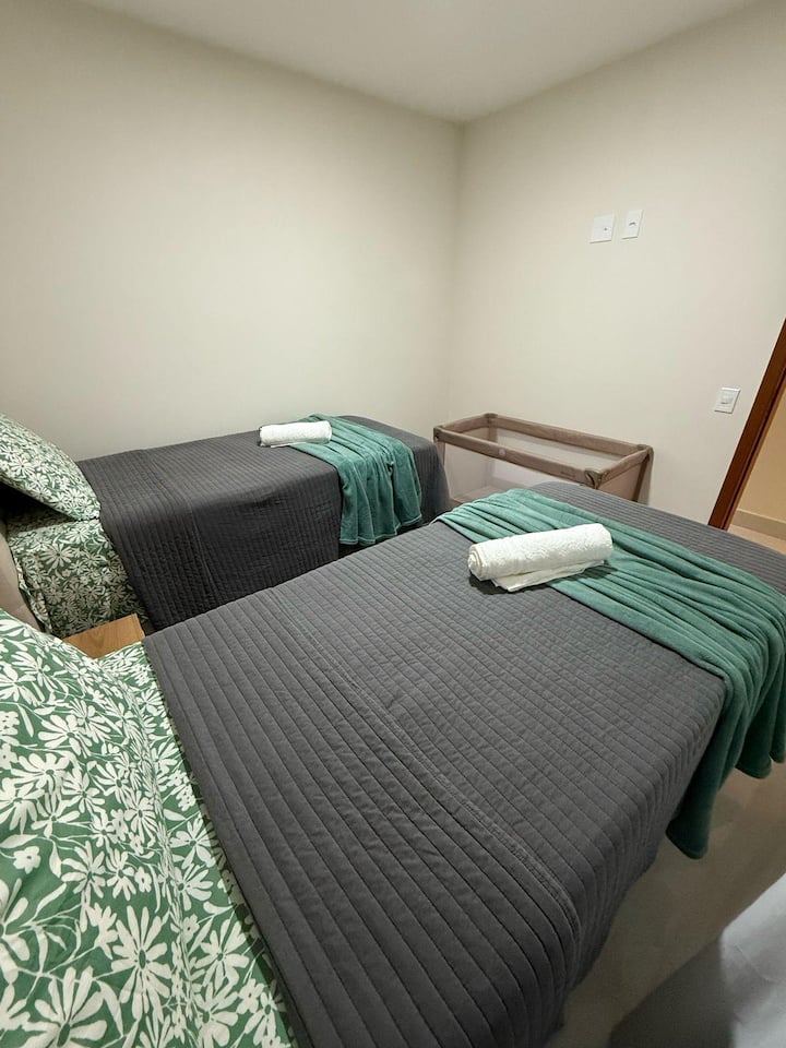 Quarto 2 equipado com 2 camas de solteiro, 2 colchões extras, ar-condicionado, local para guardar as roupas, cabides, cobertores e travesseiros extras. Berço portátil disponível mediante solicitação prévia.