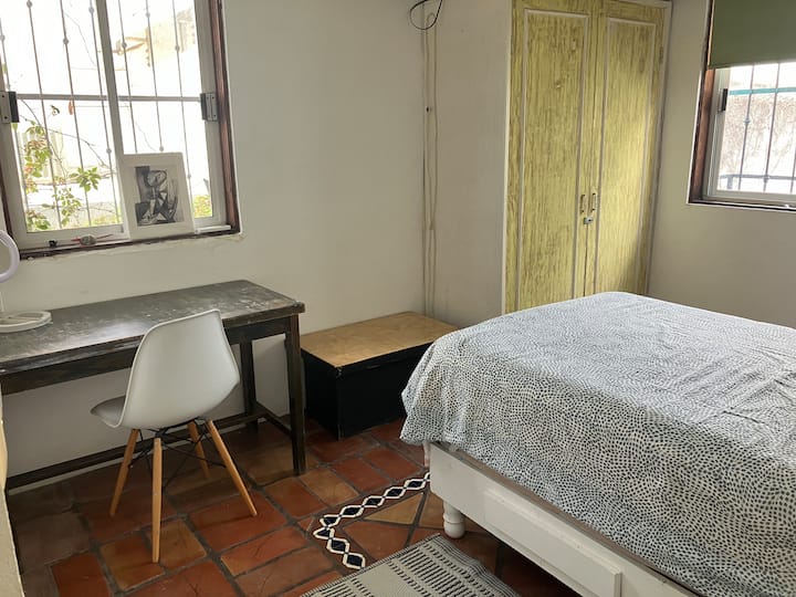 ห้องนอนสว่างมากเนื่องจากมีหน้าต่าง 2 บาน เตียงมีขนาดเดียวมีเครื่องปรับอากาศและพัดลมเพดานโต๊ะทำงานพร้อมเก้าอี้สำนักงานพร้อมโคมไฟและราวแขวนเสื้อ