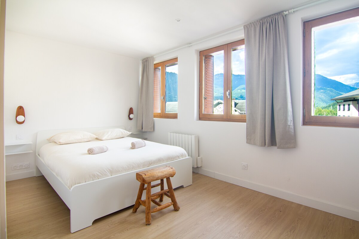 Chumba kikubwa cha kulala kina kitanda kikubwa cha watu wawili na kitanda cha mtu mmoja, kinachofaa kwa ukaaji wa starehe. Mtindo wake wa kutuliza na mandhari maridadi ya milima hufanya iwe mahali pazuri pa kupumzika baada ya siku moja nje.