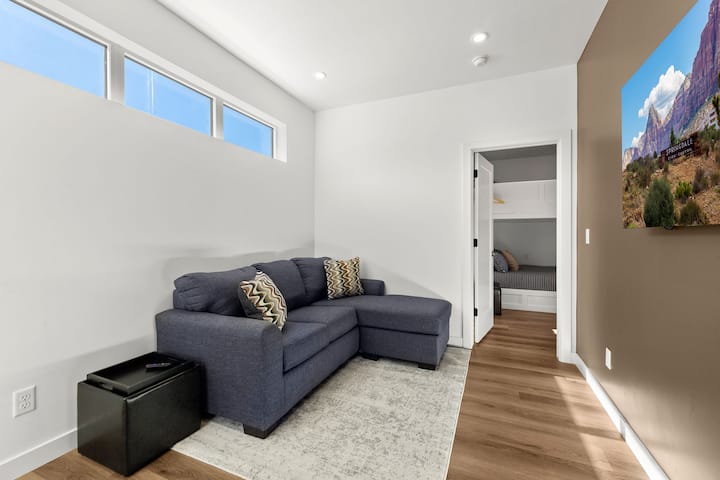 Canapé-lit queen size juste à côté de la chambre des moines avec un grand écran de 65 pouces sur lequel les enfants peuvent jouer. 