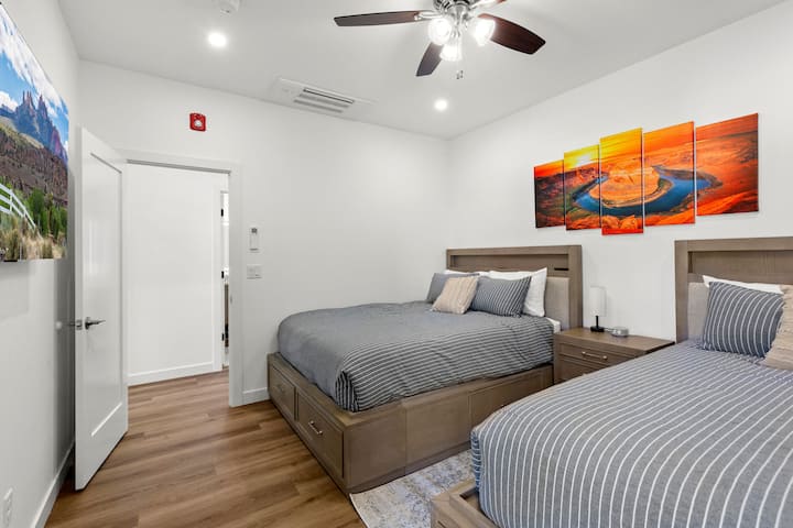 Suite de deux chambres queen size avec œuvre d'art en fer à cheval. Cèdre doublé sous les tiroirs du lit pour le stockage.