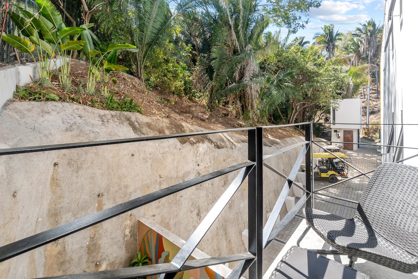 Step onto your private balcony and breathe in the hillside jungle below, a quiet perch above the golf cart lane just outside.