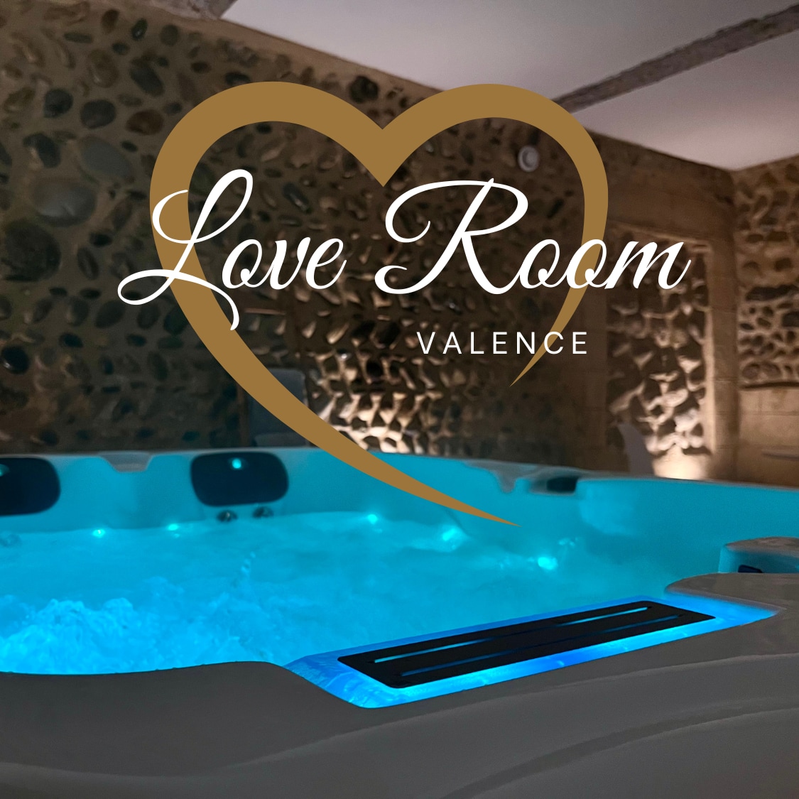 A private jacuzzi is showcased, illuminated with soft hues of blue. The surrounding decor features exposed stone walls, creating a warm ambiance. Subtle lighting enhances the relaxing atmosphere, inviting guests to unwind in a serene setting.