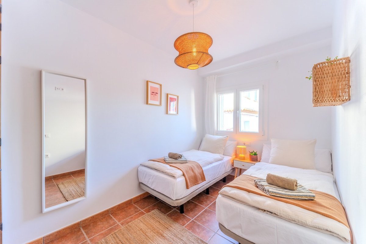 غرفة نوم مغمورة بالضوء مع سريرين مفردين مريحين وفراش موسلين عالي الجودة وتفاصيل محبة. مثالية للأصدقاء أو الأشقاء أو المسافرين الذين يتشاركون الغرفة – لليالي الاسترخاء في محيط هادئ.