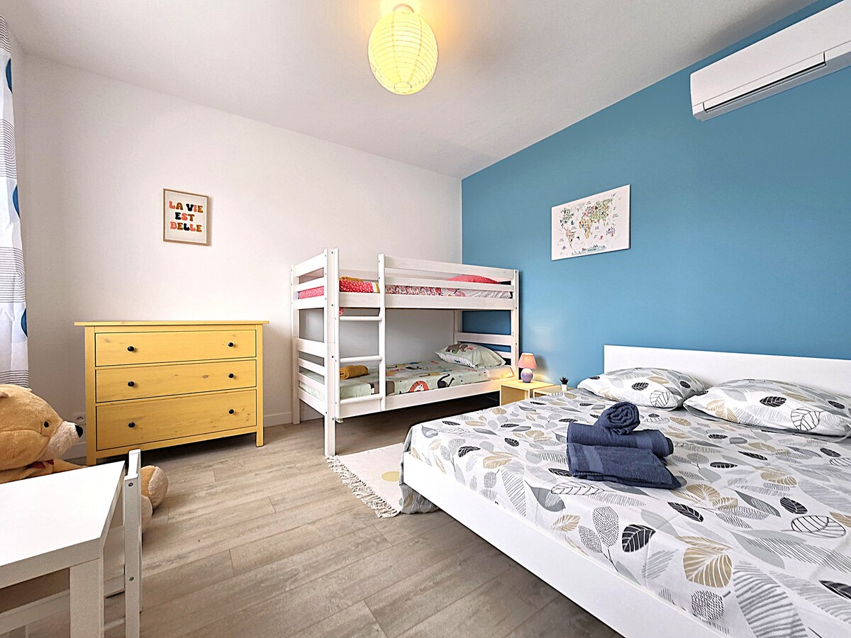 Familiekamer met twee 90 stapelbedden en een 140 tweepersoonsbed, opbergruimte, kindertafel en stoel, omkeerbare airconditioning. Handdoeken en bedlinnen aanwezig.
