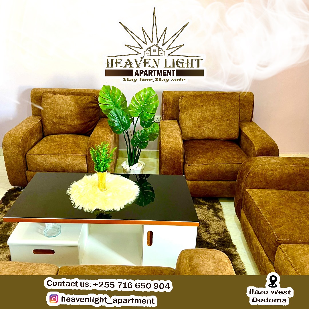 A cozy living area is presented with two brown armchairs and a modern coffee table featuring a white surface and storage compartments. A potted green plant adds a touch of nature. Light is reflected softly from the room's walls.