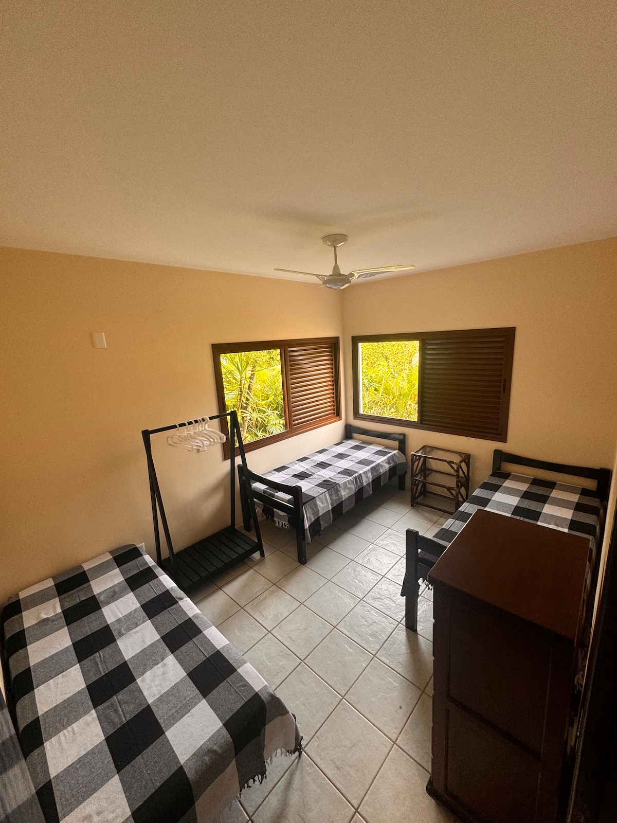 Habitación con 3 camas individuales, ventilador de techo, cómoda y cajón grande. Se encuentra en la planta baja de la casa.