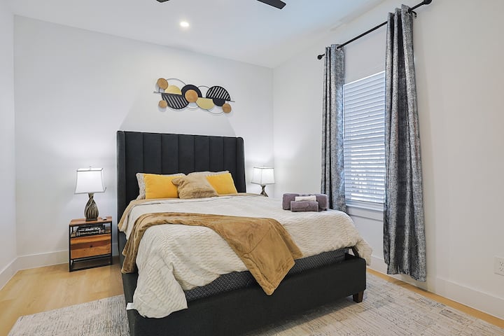 Segundo dormitorio diseñado con estilo y lujo  y equipado con una cama tamaño queen, mesa de noche y un televisor inteligente de 65pulgadas.