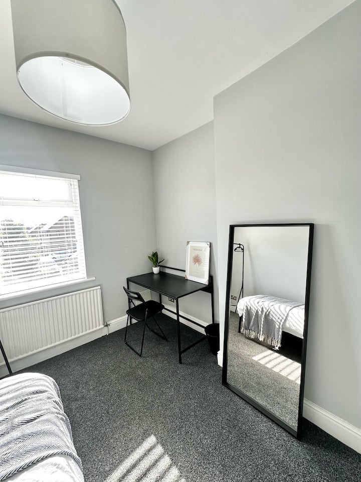 Удобна соба со единечен кревет, биро за работа или одмор и големо огледало. Исто така, вклучува ограда за облека за погодно складирање, нудејќи удобен и функционален простор за самостоен престој. Идеално за релаксација и продуктивност.