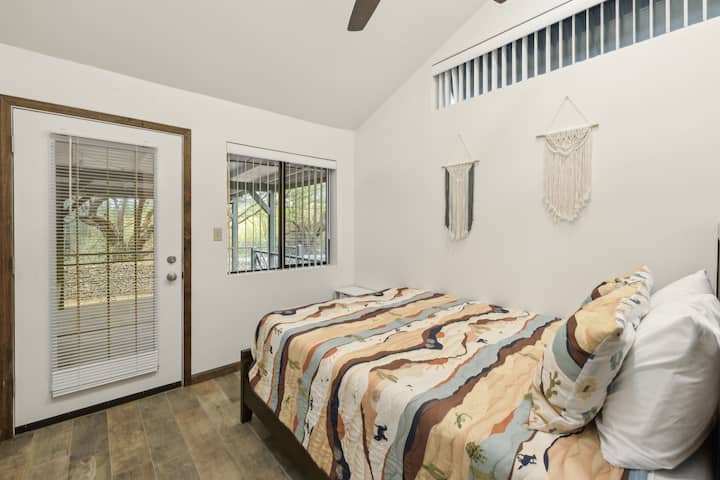 חדר שינה בהיר ומאוורר עם מיטת קווין סייז, תקרות קמורות, מצעים בהשראת המדבר וגישה ישירה לפטיו המקורה - מושלם לקפה בוקר או לערבים שקטים תחת כיפת השמיים.