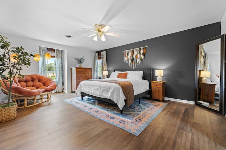 Спалня 1: На горния етаж, спокойно спане в светлия и стилен основен апартамент, с голямо двойно легло, гардеробна стая и спокойни детайли в дизайна. Просторно! Легло с кралски размер, двуместен папасан, огледало в цял ръст и място за съхранение на дрехи.