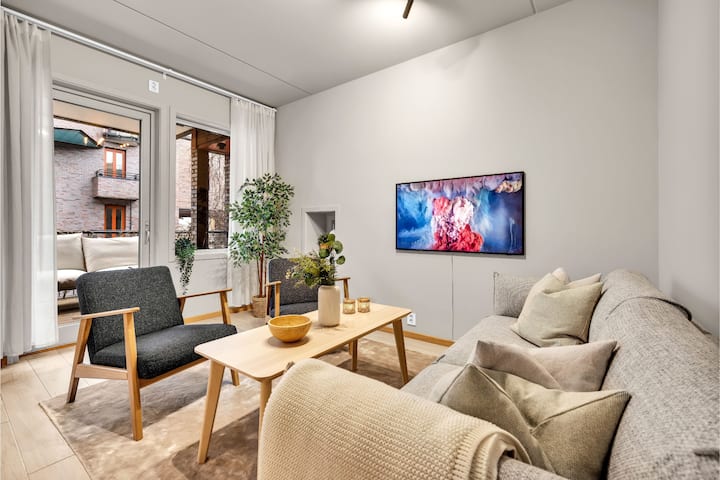 In de woonkamer zijn er zitgroepen en een aan de muur gemonteerde smart-tv waar u gebruik kunt maken van uw eigen streamingdiensten. Er is een open oplossing in de woonkamer, met open keukenoplossing, eettafel en uitgang naar het balkon. 