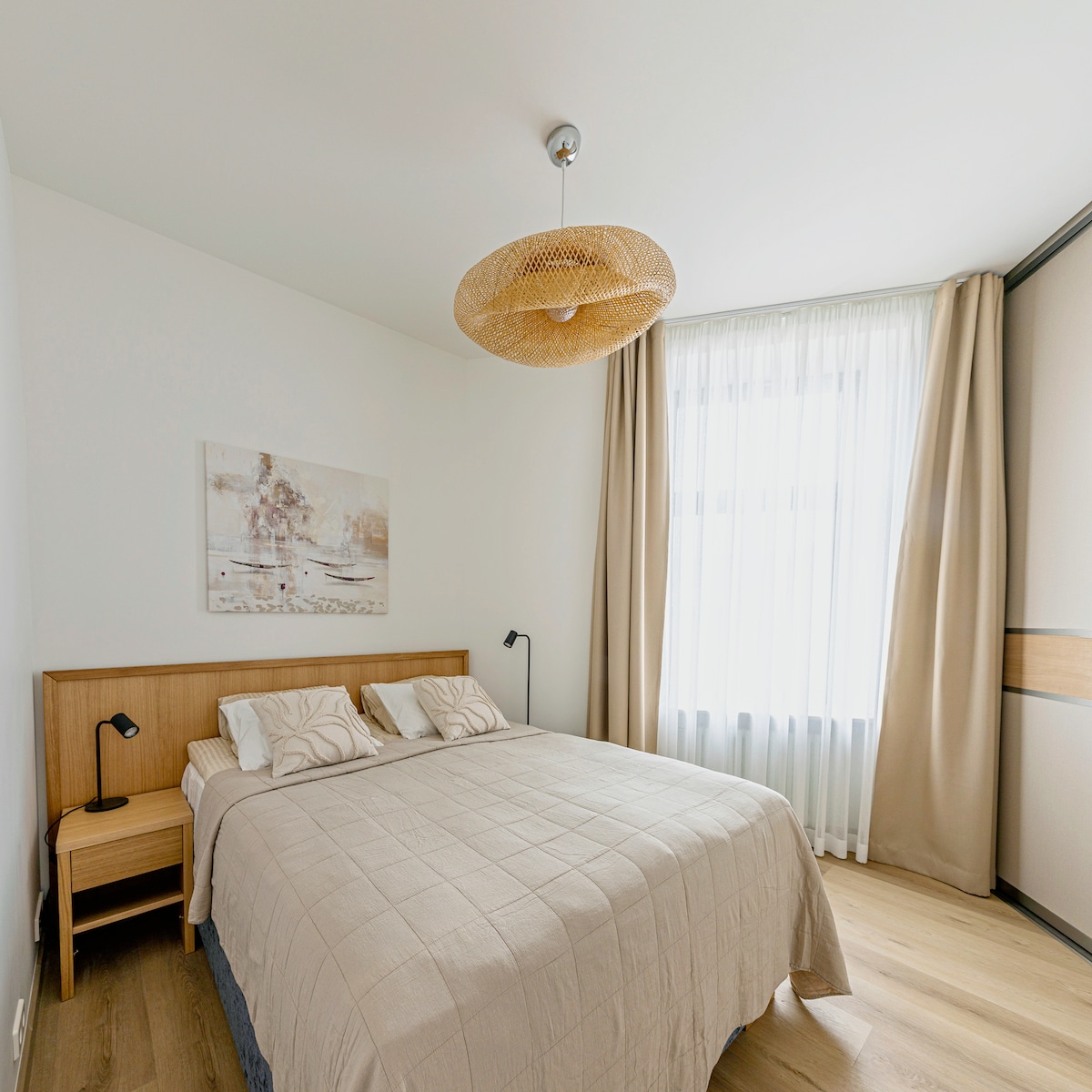 Bedroom with a king-size bed & nightstand with a night lamp on each side.